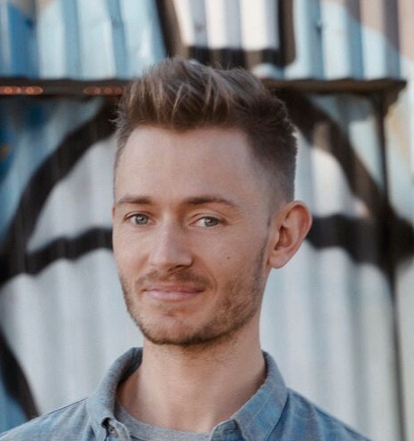 Headshot of Andy Campbell smiling softly, wearing a blue denim shirt